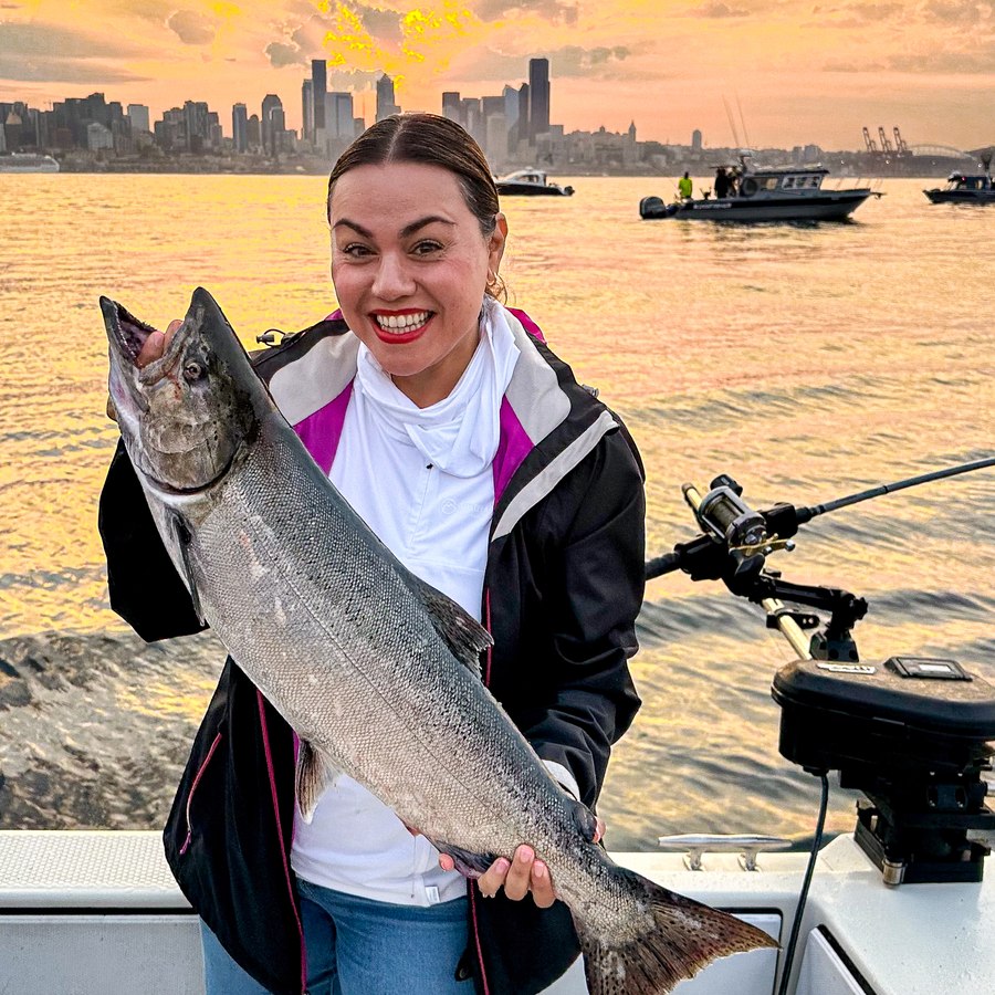 Jessica holding a king salmon on a boat in Seattle